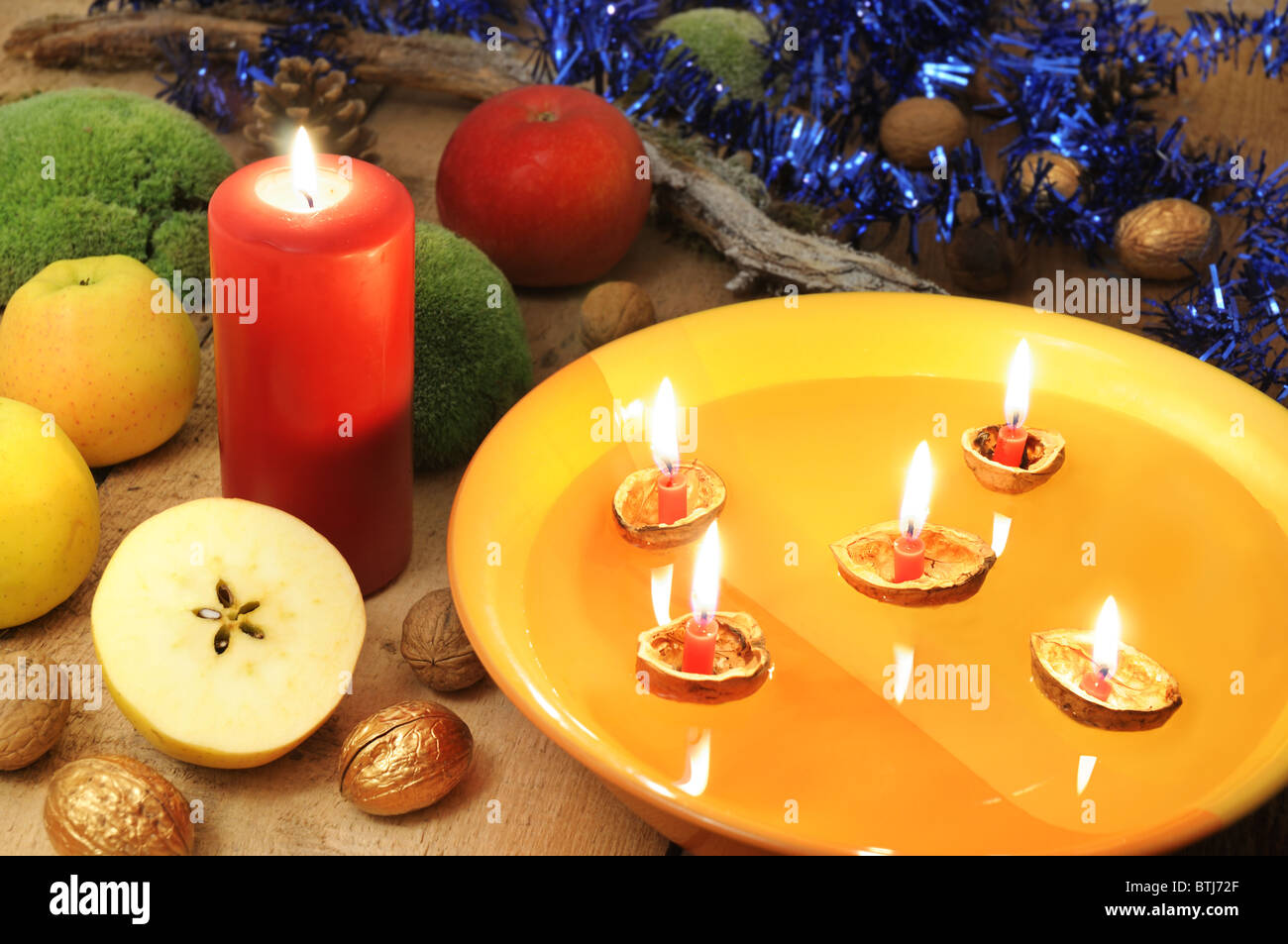 Christmas customs - walnut shell boats and half cut apple in Christmas decoration. Stock Photo