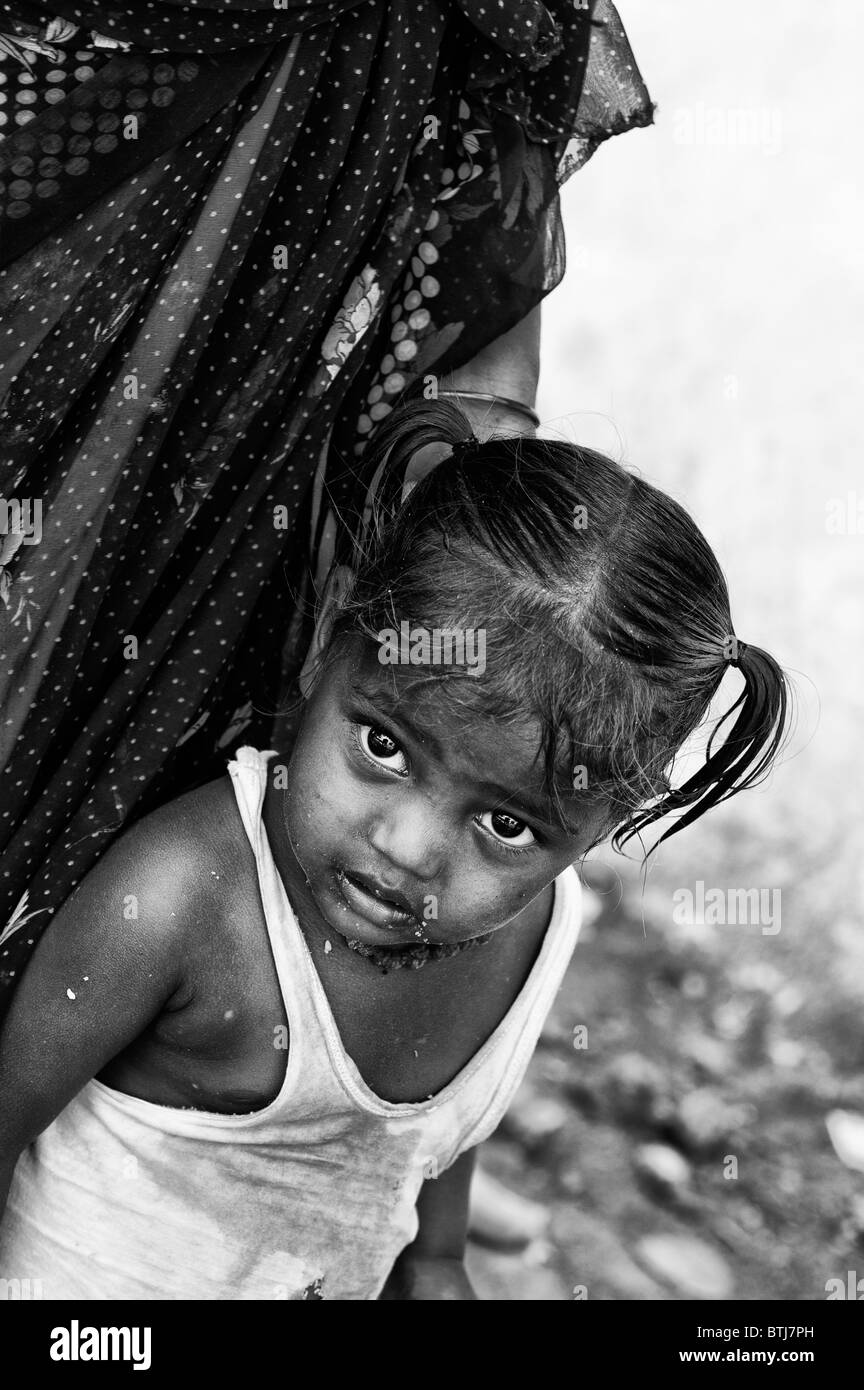 Poor indian baby girl with mother on the street in India. Black and White with selective focus. Stock Photo
