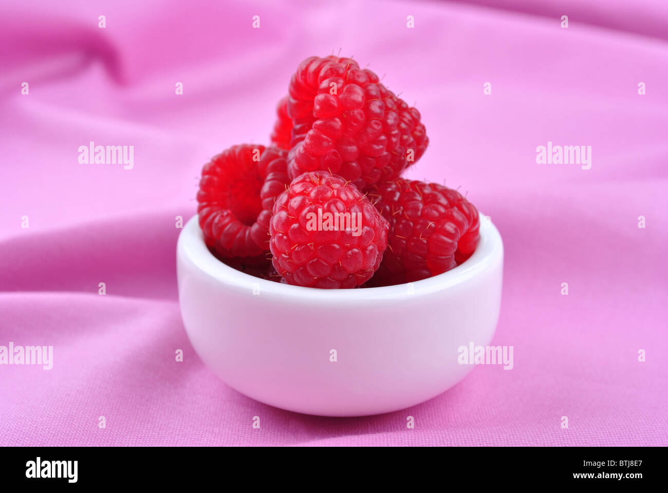Some Raspberries some organic raspberries in a small white bowl Stock Photo - Alamy