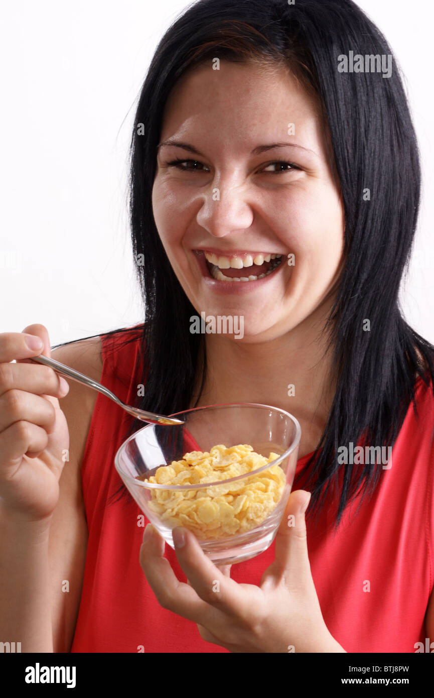 a young woman eating corn flakes from a bowl Stock Photo - Alamy