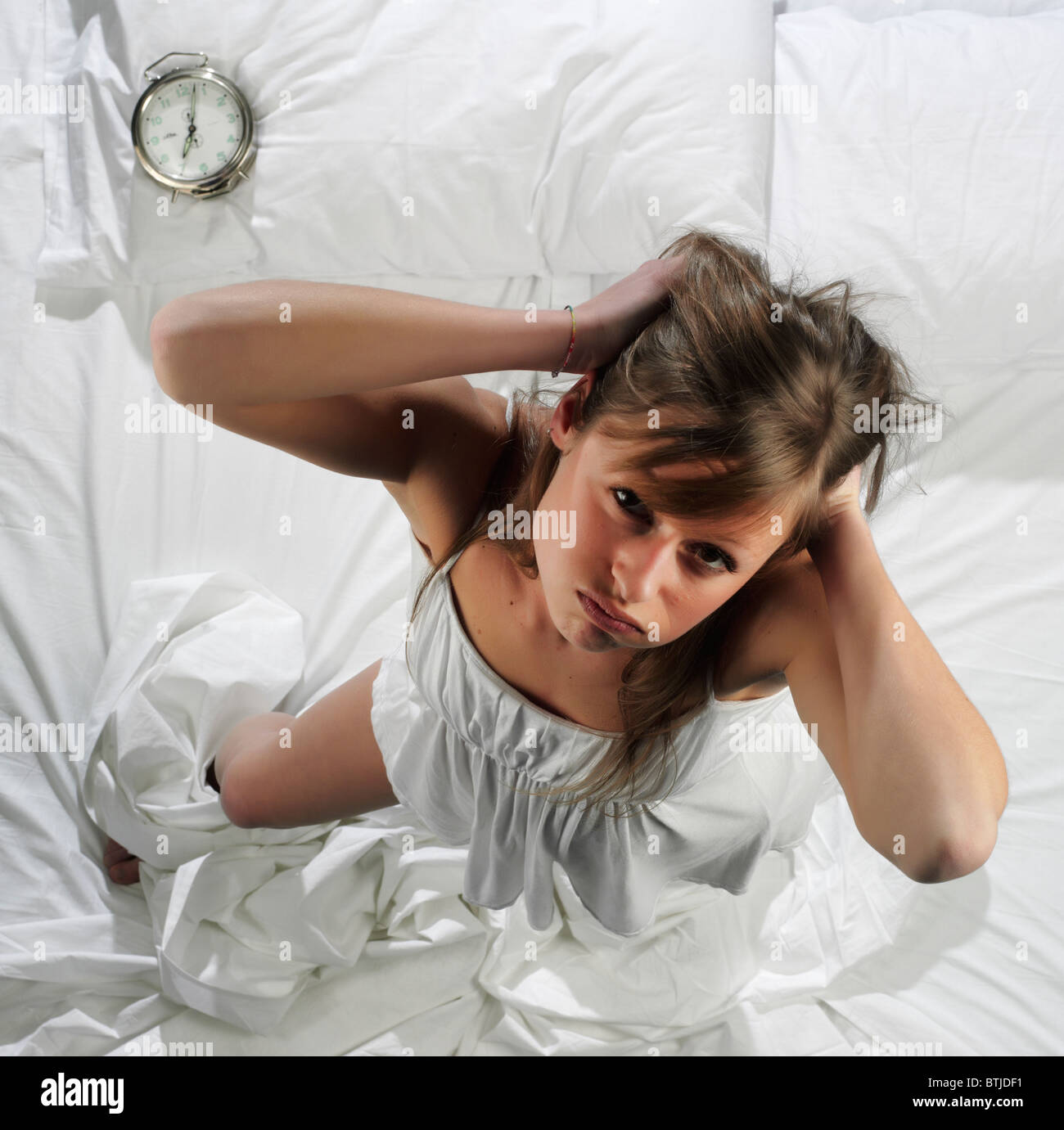 Woman in bed with alarm clock Stock Photo Alamy