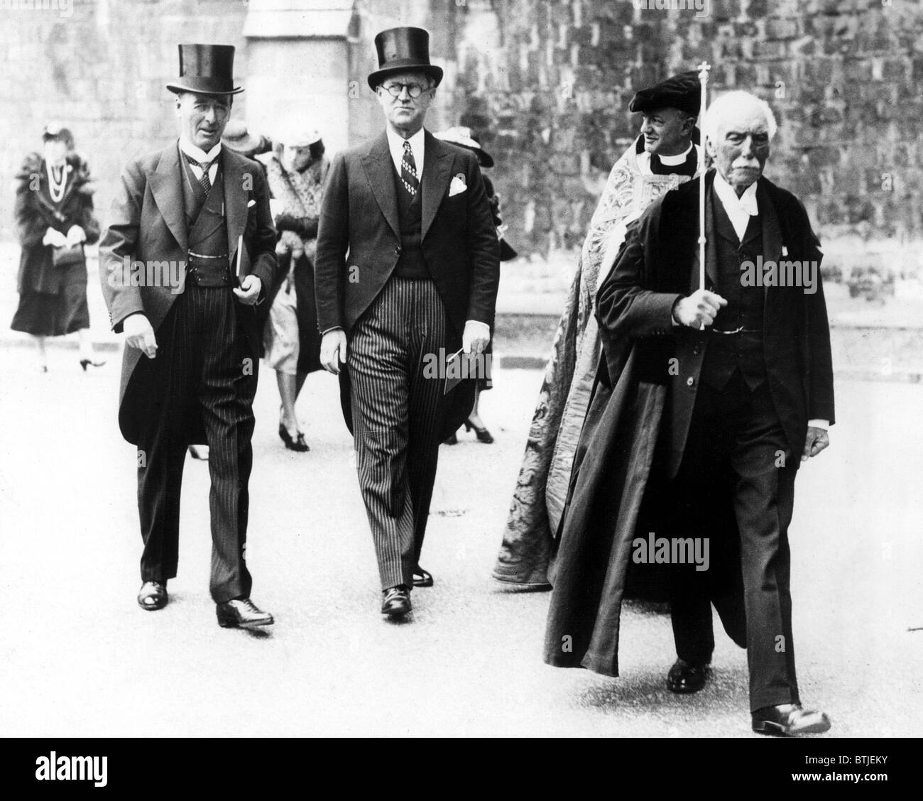 WINCHESTER, ENG: Joseph P. Kennedy (center), U.S. Ambassador to Britain, walking with Lord Mottistone (left), Lord Lieutenant of Stock Photo