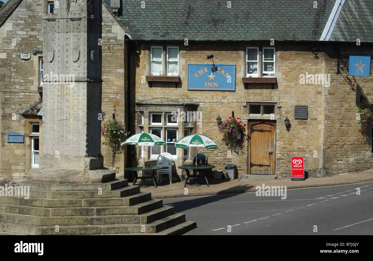The Star Inn, under the shadow of the Queen Eleanor Cross, at Geddington, Northamptonshire, UK Stock Photo