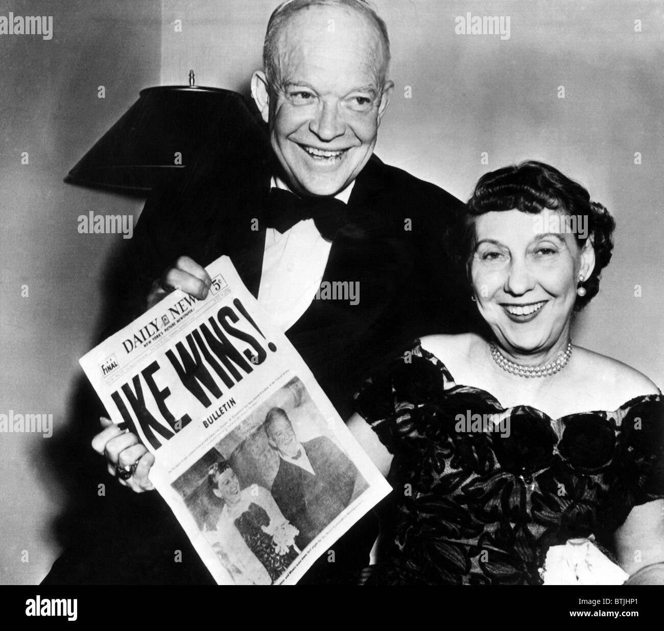 President Dwight D. Eisenhower and his wife, Mamie Eisenhower hold up a copy of the New York Daily News headlining Eisenhower's Stock Photo
