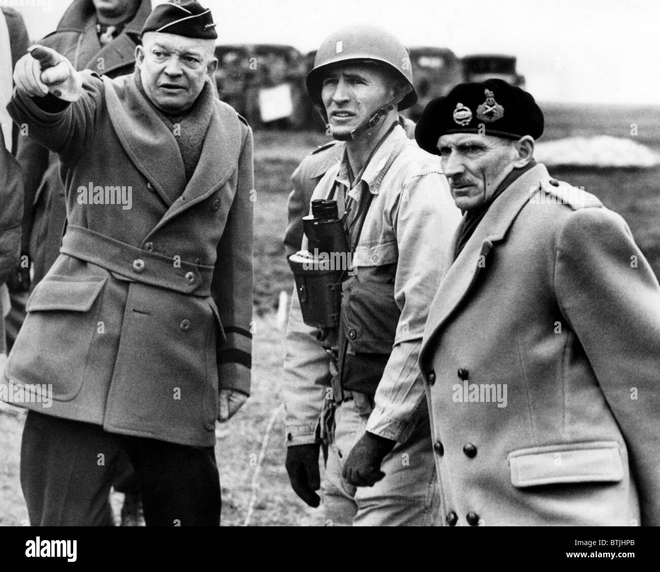 General Dwight D. Eisenhower and Britan's Field Marshall, Bernard Montgomery (far right) confer on the invations plans of Norman Stock Photo