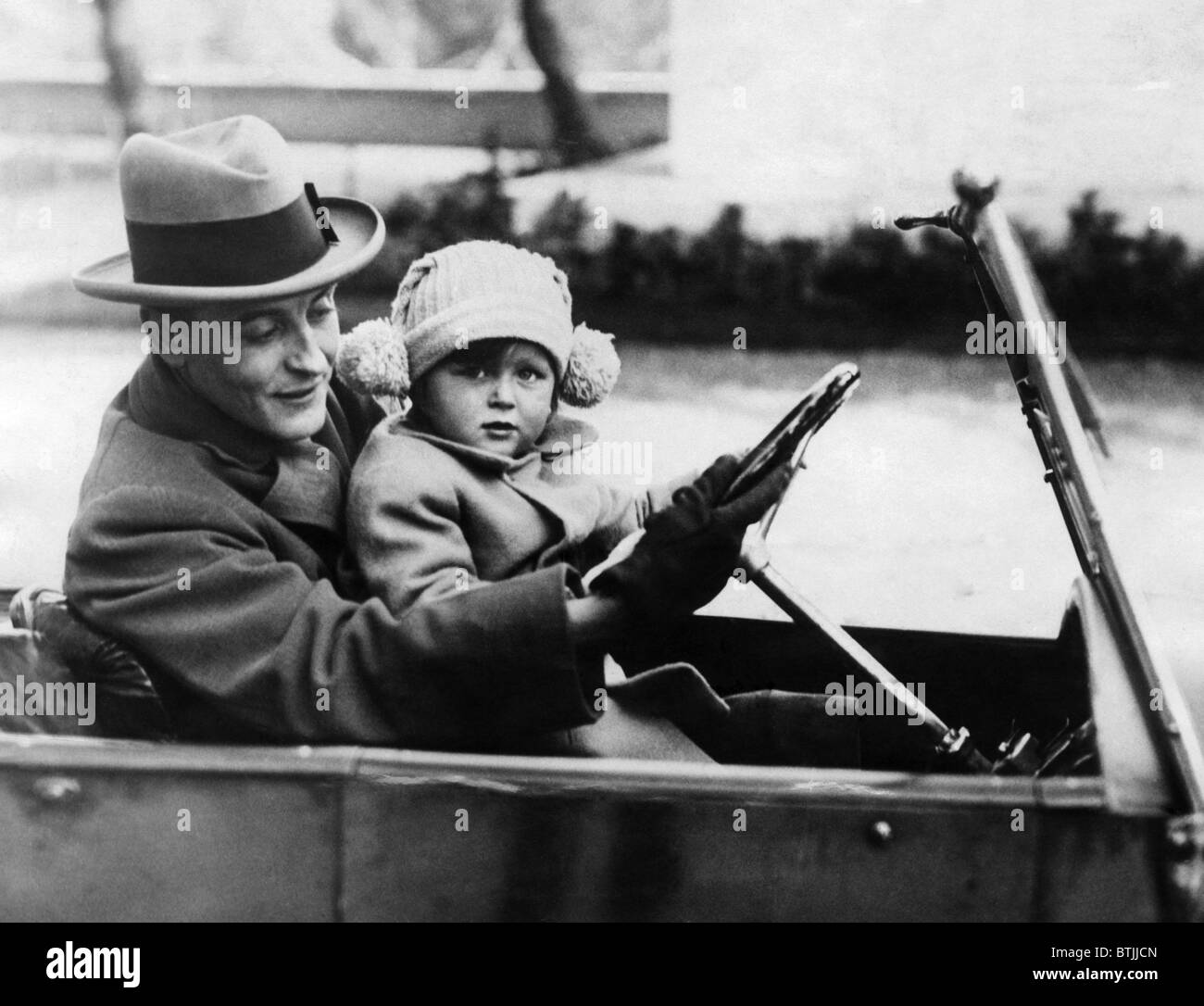 F. Scott Fitzgerald shows his daughter how to drive in Rome. 1924-1931. Courtesy CSU Archives/Everett Collection. Stock Photo