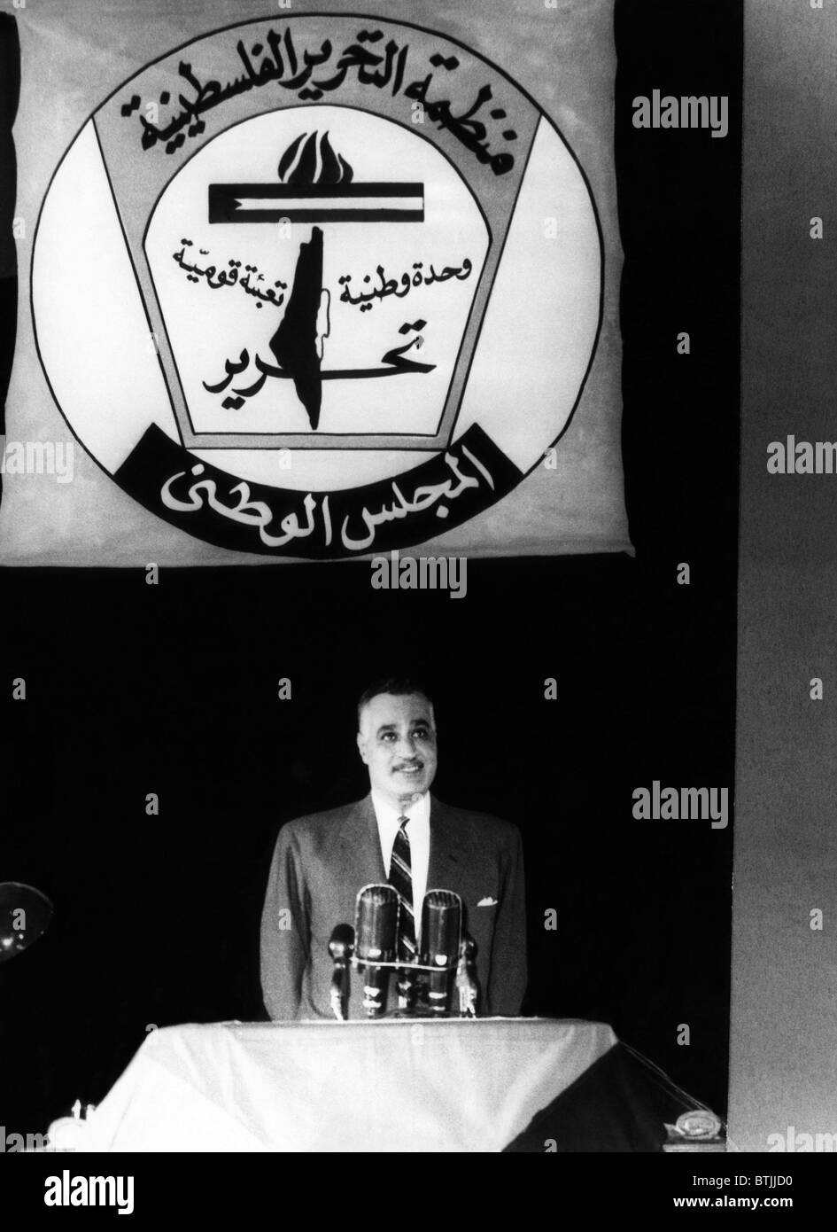 President of the United Arab Republic Gamal Abdel Nasser, standing under the symbol of the PLO (Palestine Liberation Organizatio Stock Photo