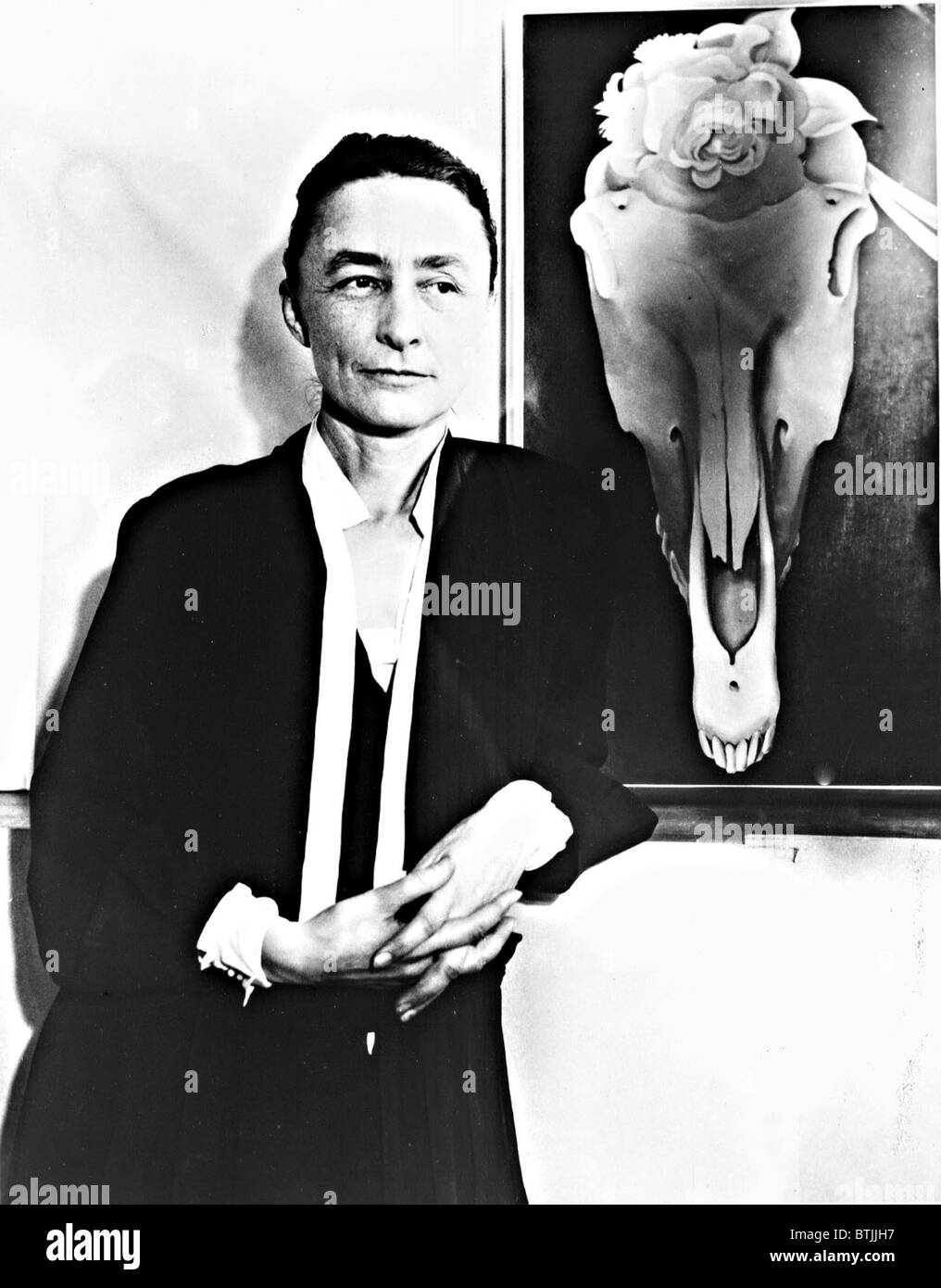 Georgia O'Keeffe and one of her skull paintings, 1931. Photo courtesy: Everett/CSU Archives. Stock Photo