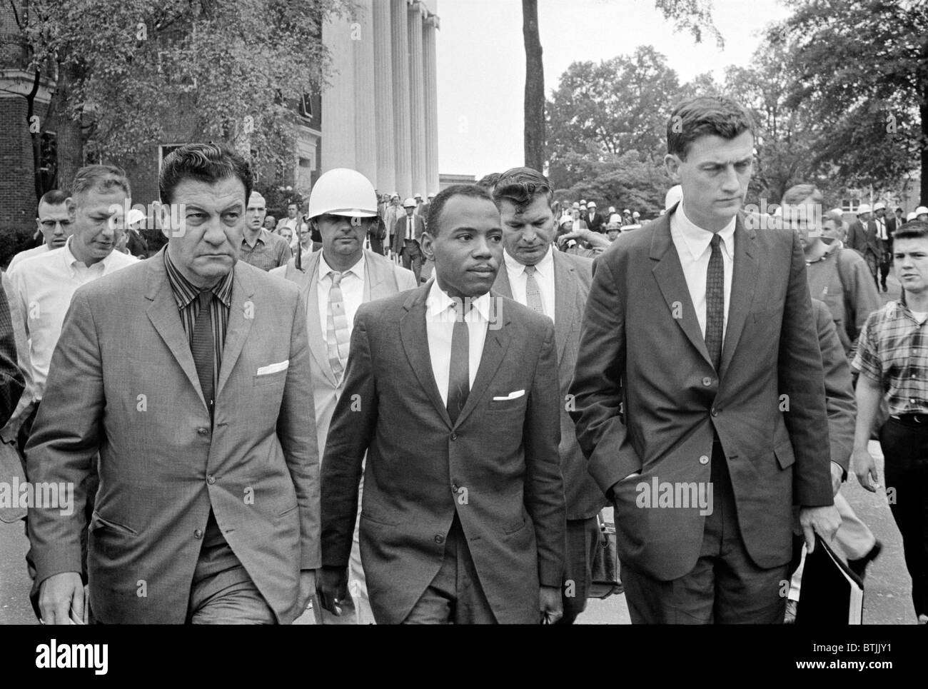Integration at Ole Mississippi University, James Meredith (center), walking to class accompanied by U.S. marshals, by Marion S. Stock Photo