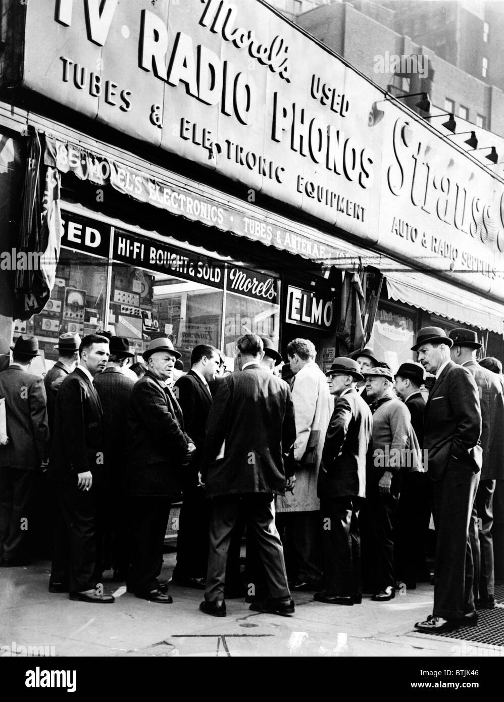 Crowd listens outside radio shop at Greenwich and Dey Sts. for news on President Kennedy. Photo by Orlando Fernandez, November 22, 1963 Stock Photo