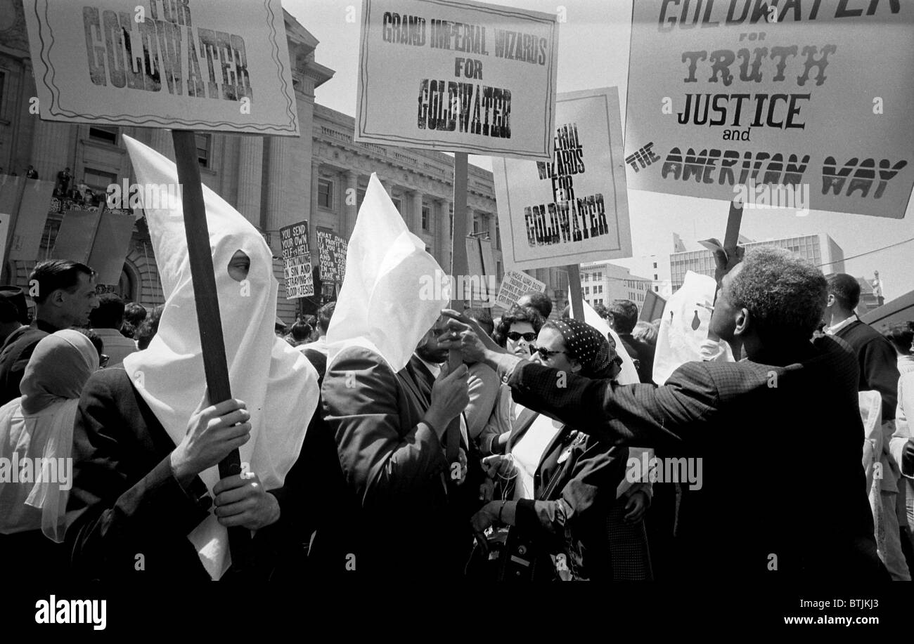 Ku Klux Klan members supporting Barry Goldwater's campaign for the presidential nomination at the Republican National Convention. An African American man pushes back. by Warren K. Leffler, San Francisco, California, July 12, 1964. Stock Photo