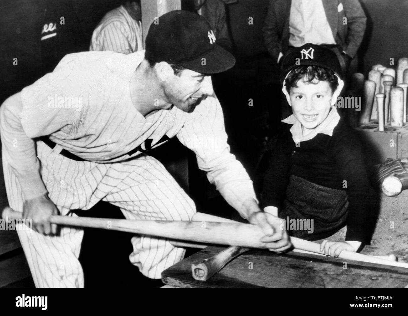 Joe DiMaggio shows his son, Joe Jr., how to bone down a baseball bat, 1946. Courtesy: CSU Archives/Everett Collection Stock Photo