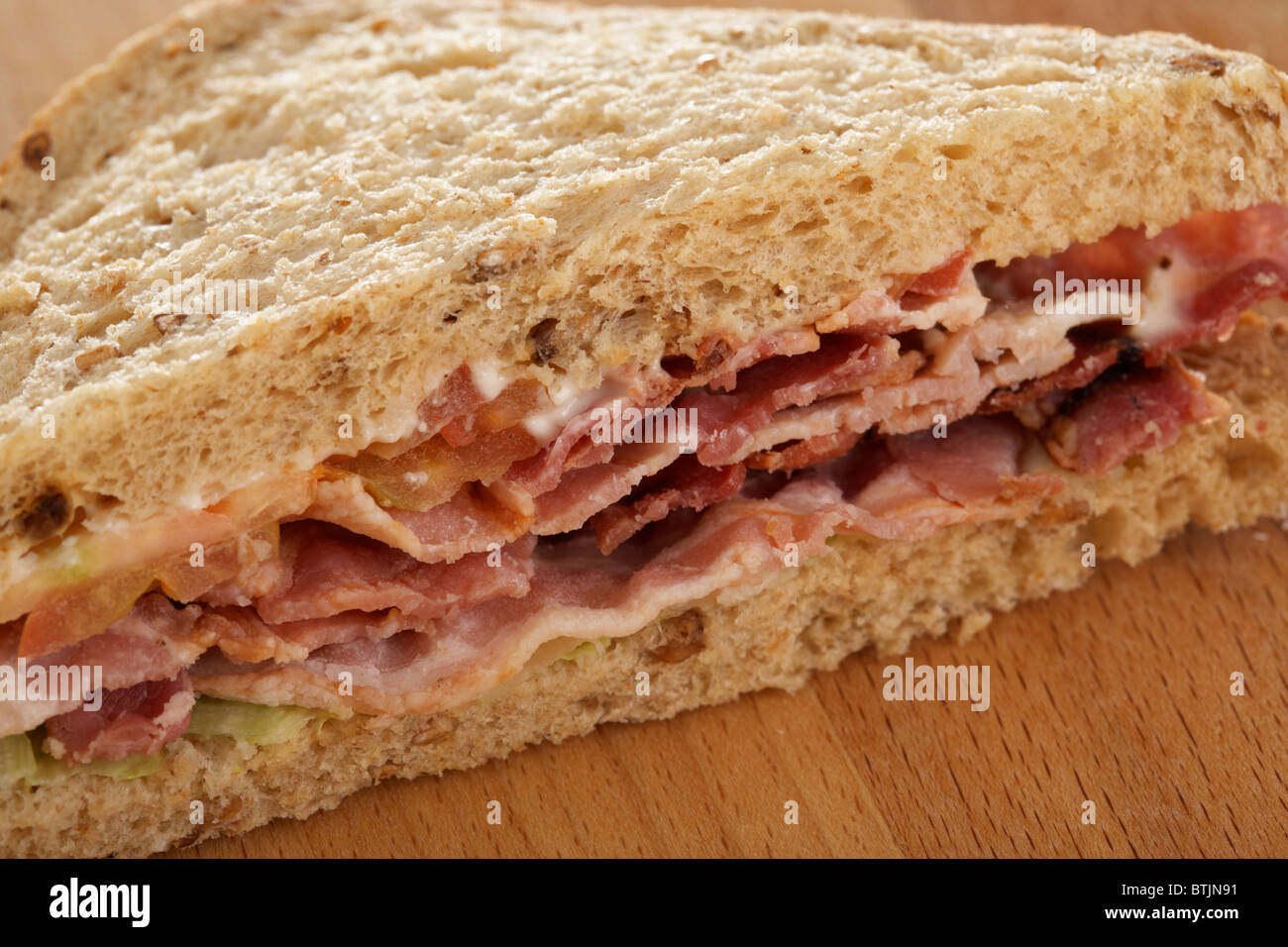 single triangle blt bacon lettuce tomato sandwich in malted brown malt bread Stock Photo