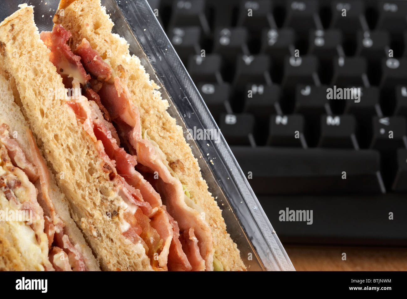 takeaway triple sandwiches in carton next to computer keyboard at ...