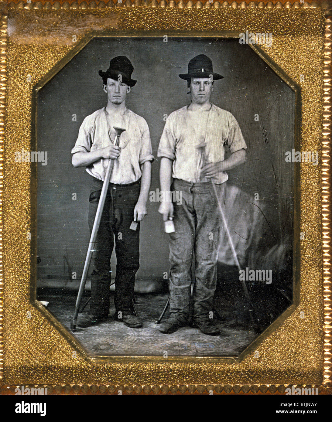 Two men holding floor rammers, foundry tools used for packing sand against molds, sixth-plate daguerreotype, with Eichmeyer variant case, circa 1850. Stock Photo