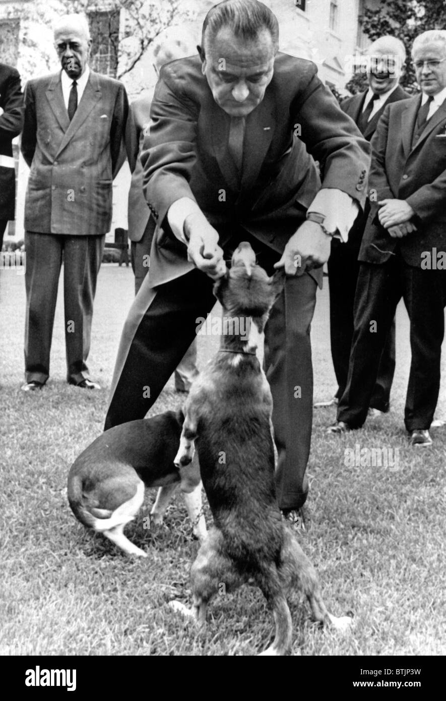 President Lyndon Johnson pulling the ears of the White House beagles