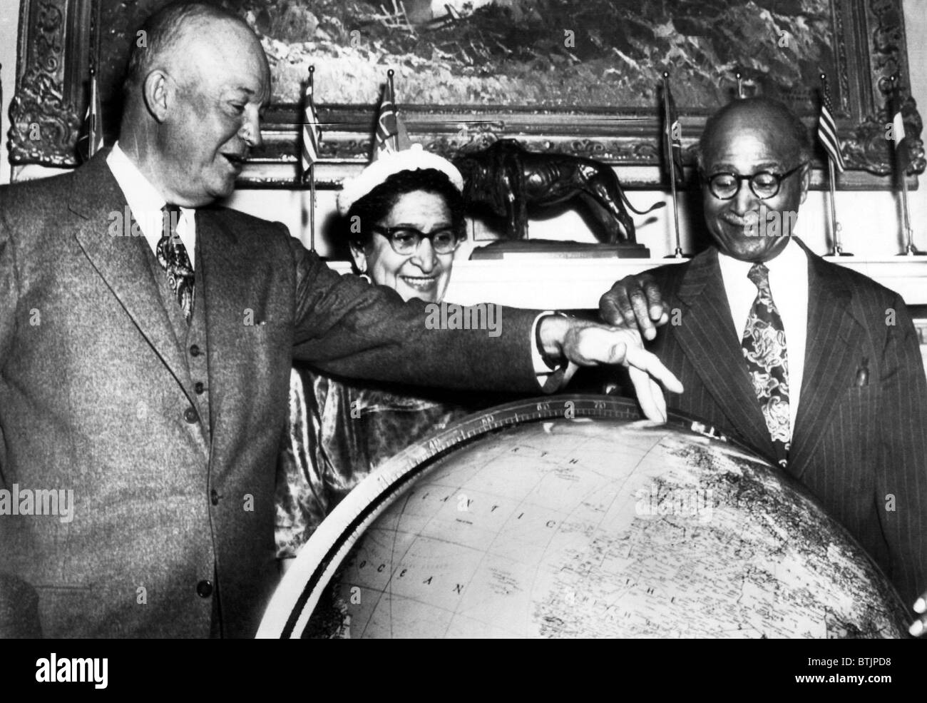 During a visit to the White House, Explorer Matt Henson helps President Eisenhower locate the spot on a globe where he reached t Stock Photo