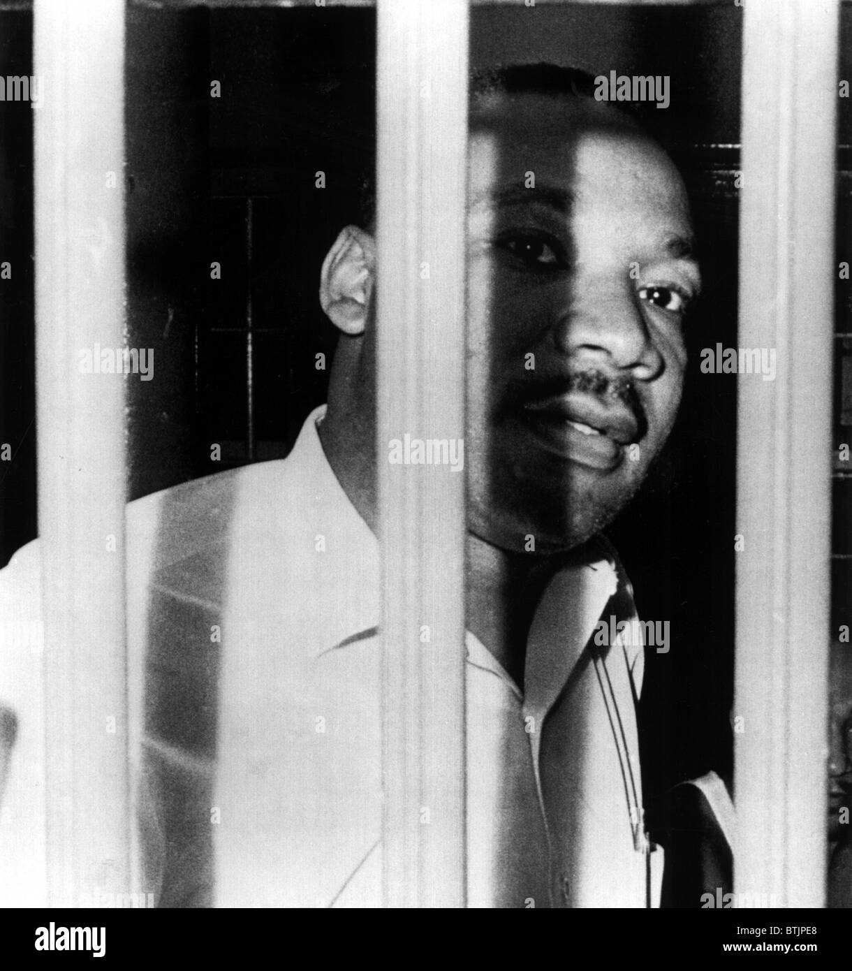 MARTIN LUTHER KING, JR, peers between the bars of his jail cell in the St. John's County Jail, Florida. He was arrested for tres Stock Photo