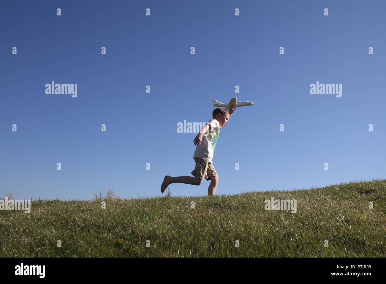 young boy running w/toy airplane,ready to let it fly Stock Photo