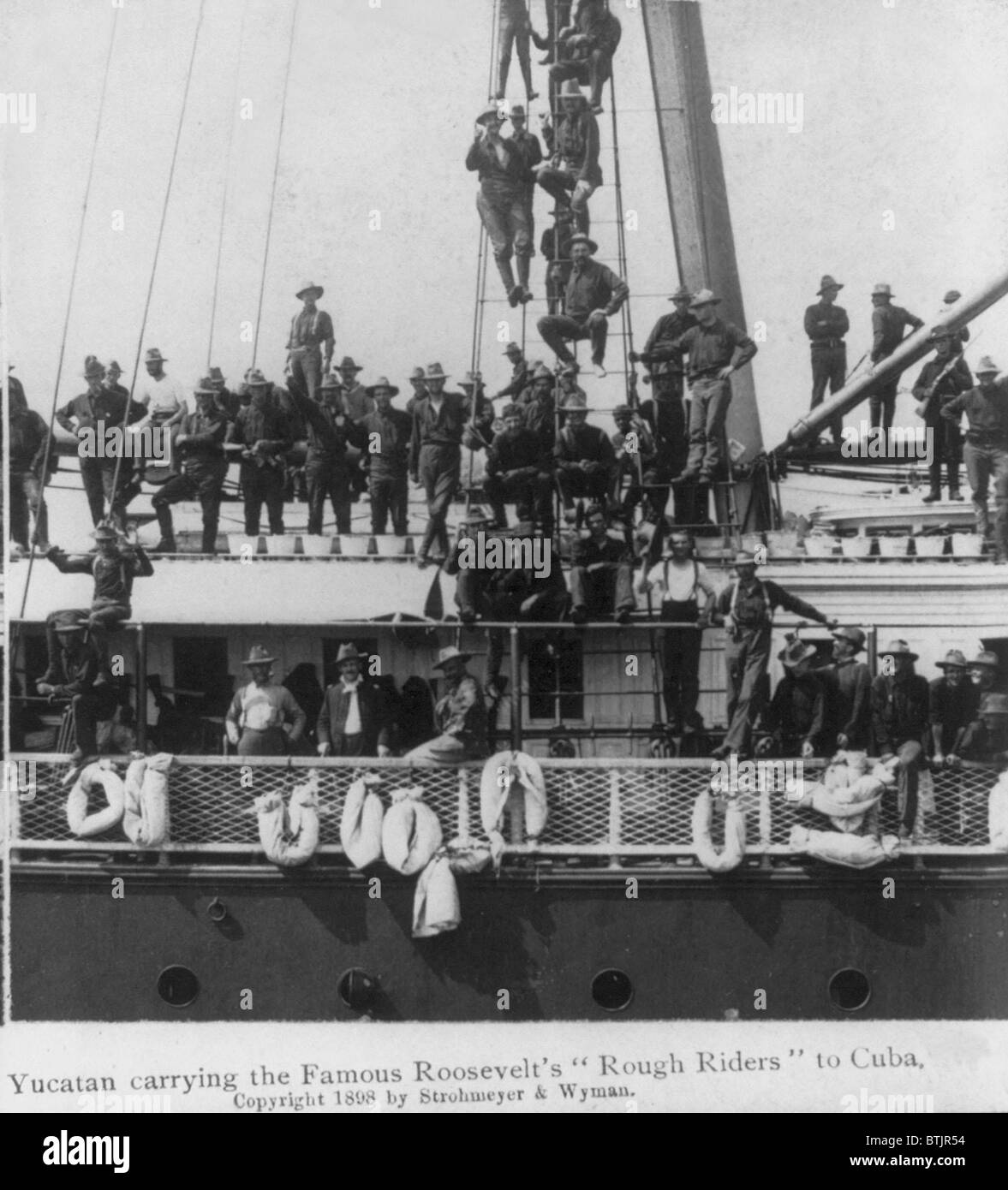 During the Spanish American War, the ship, the USS YUCATAN, carries Roosevelt's 'Rough Riders' to Cuba. Men line decks and rigging, 1898 Stock Photo