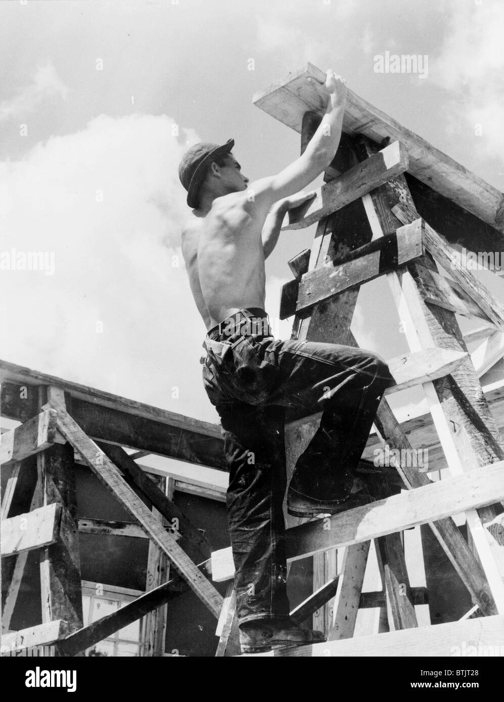Civilian Conservation Corps at work. Enrollee William L. Cross climbing up on a scaffold erected for assembling a prefabricated Stock Photo