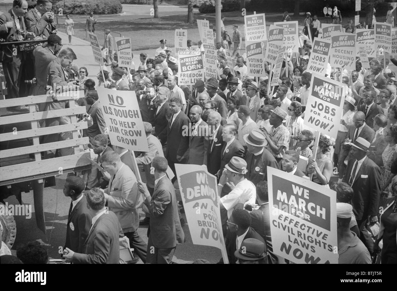 Civil rights march on Washington DC, photograph shows civil rights leaders, including Martin Luther King Jr. (center left, to right of sign reading 'No U.S. dough to help Jim Crow Grow'), surrounded by crowds carrying signs, photograph by Warren K. Leffler, August 28, 1963. Stock Photo
