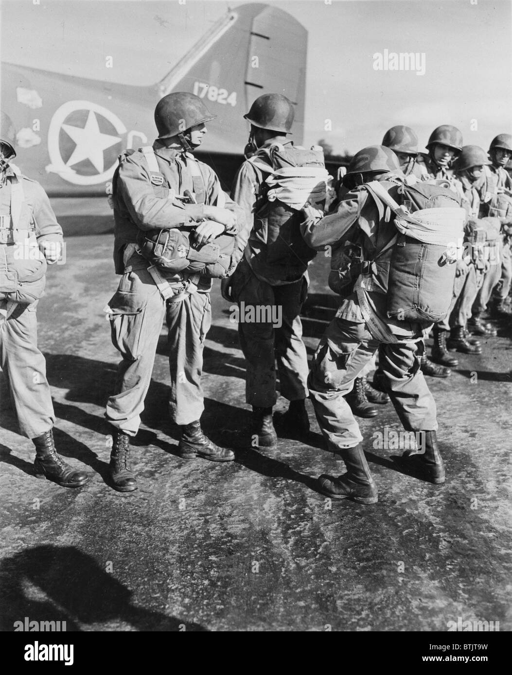 World War II, U.S. paratroopers inspecting parachutes before taking off on maneuvers in England, circa 1942. Stock Photo
