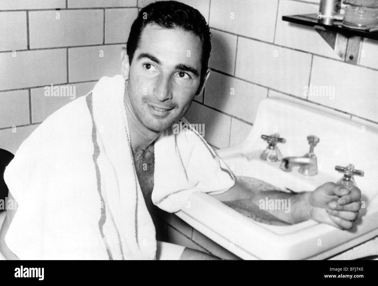 Major League baseball player Sandy Koufax, bathing his arm in ice water after pitching a seven-hitter for the Los Angeles Dodger Stock Photo
