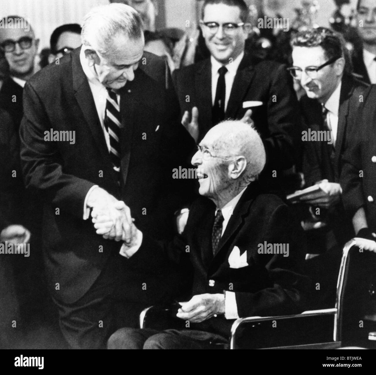 Foreground: President Lyndon Johnson (left), shaking hands with writer Upton Sinclair, (who wrote 'The Jungle', a criticism of t Stock Photo