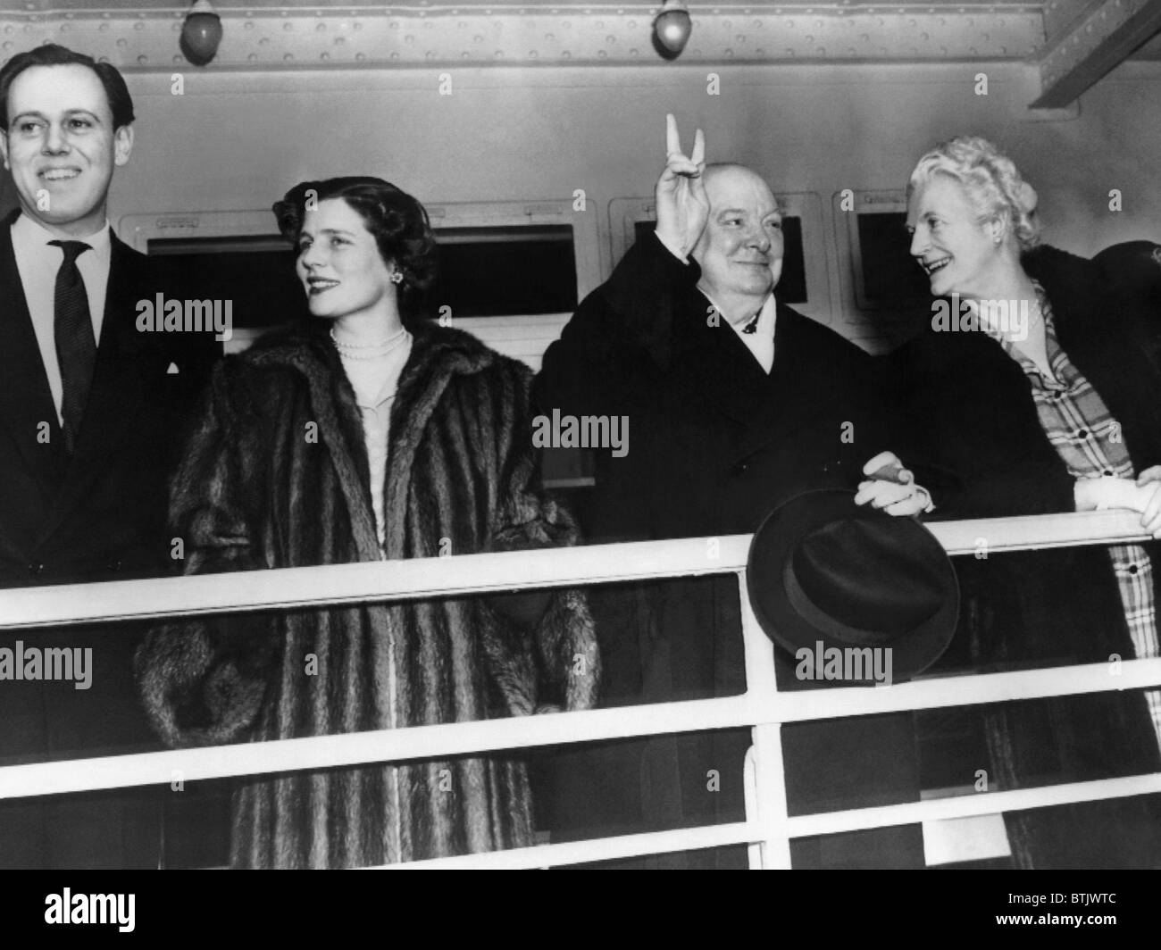 Winston Churchill gives the victory sign as he arrives in New York with Captain Christopher Soames, Mary Churchill and Clementin Stock Photo