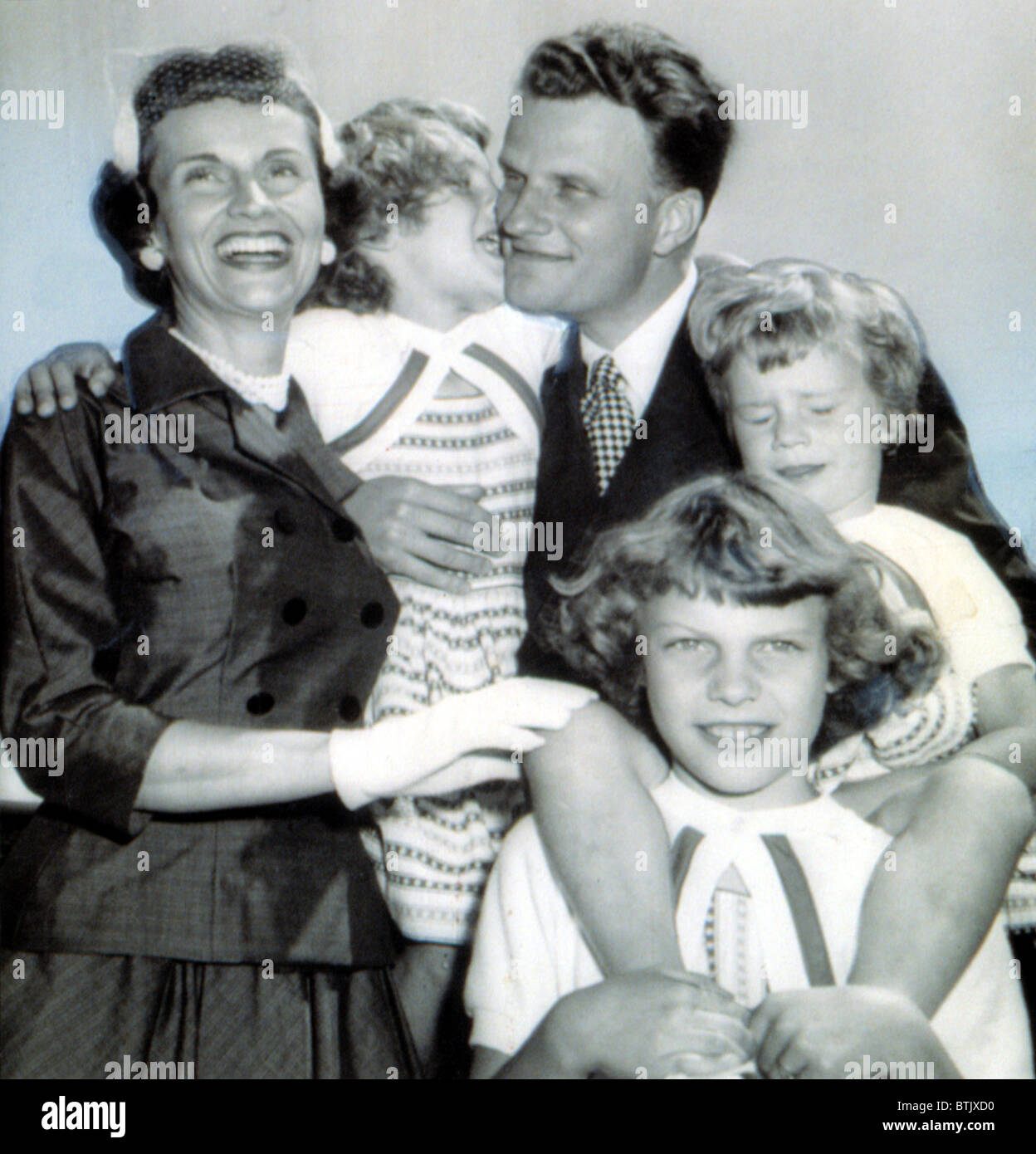 Billy Graham greeted by wife, Ruth & daughters Virginia,8, Anne,6, and Ruth, 3.  7/6/54. Stock Photo