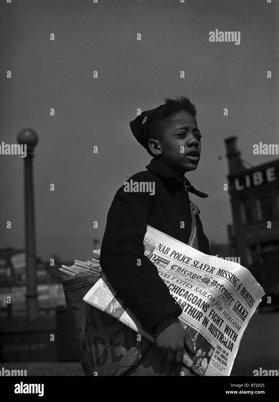 African American newsboy, original caption 'Newsboy selling the Chicago Defender, a leading