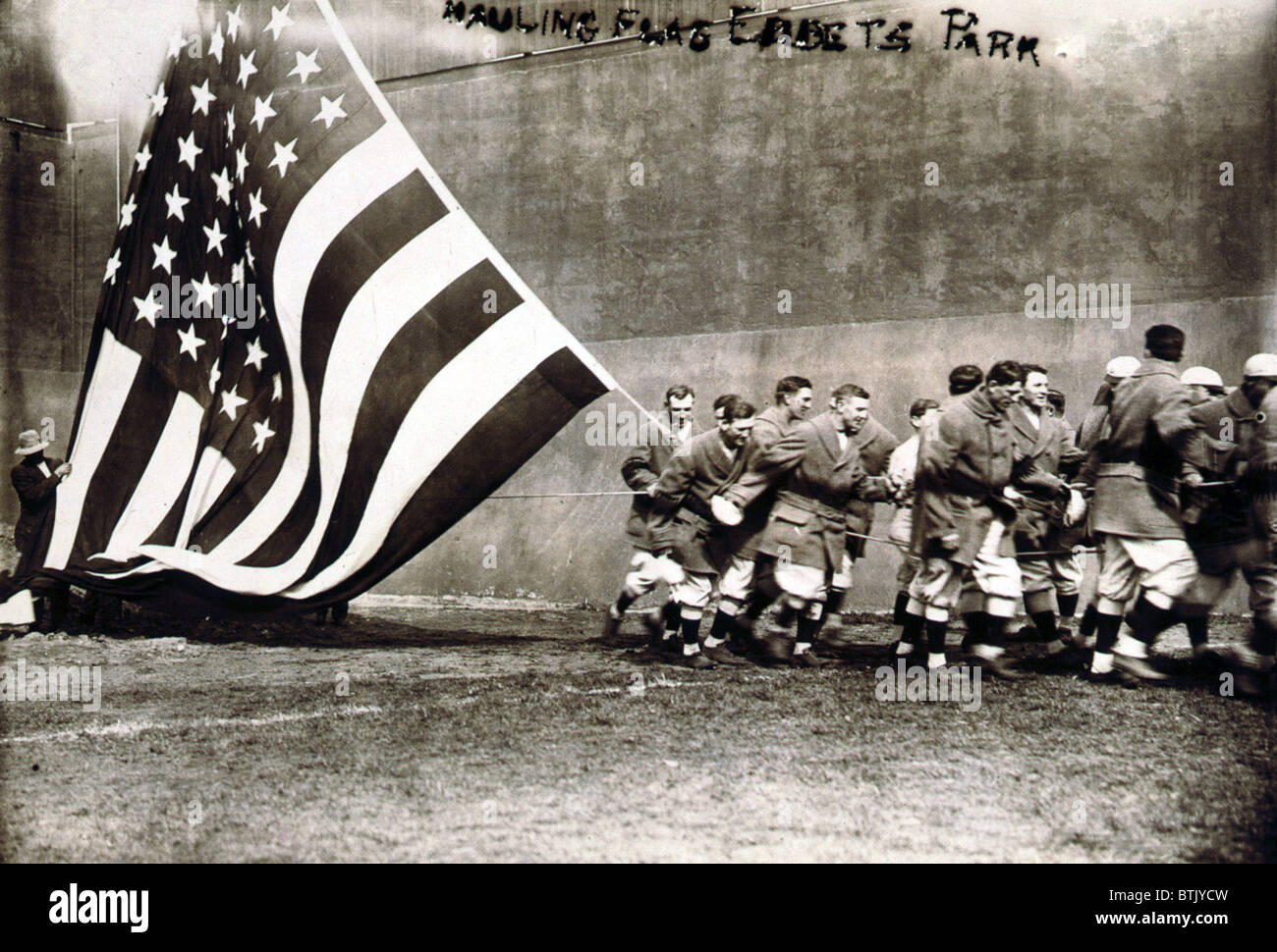Old Glory. Group of men raising large American flag on opening day of the 1914 baseball season, in Ebbets Field, NY, April 14, 1914 Stock Photo