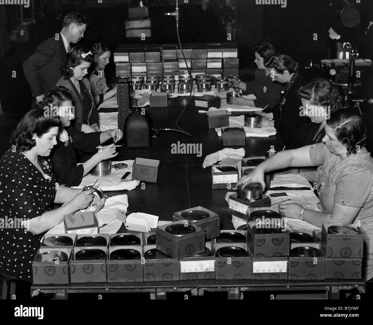 Women take part in World War II production, inspecting pistons for aircraft engines at the Buick plant in Flint, Michigan, circa Stock Photo