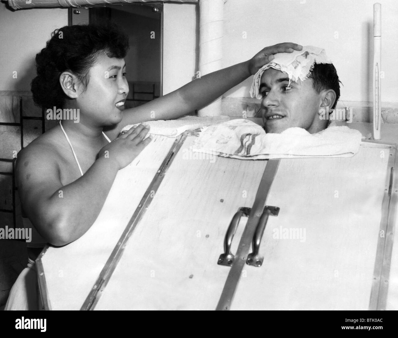 A Japanese masseuse applies a cold towel the the head of a GI in a steam  bath.ca 1951.Courtesy: CSU Archives/Everett Collection Stock Photo - Alamy