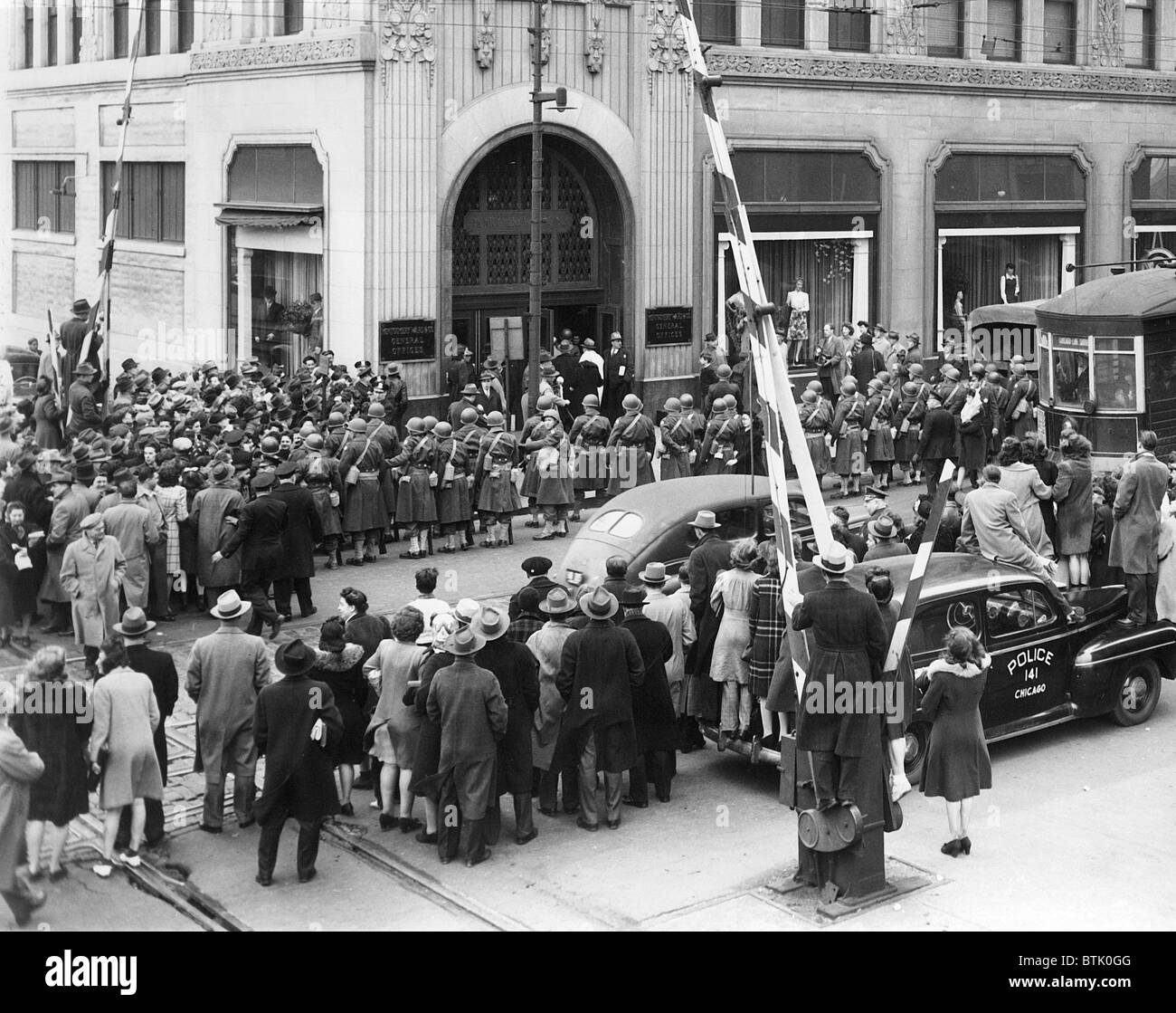 Montgomery Ward and Company, Chicago, employees and crowds watch, as military police & US Marshals arrive to enforce FDR's order Stock Photo