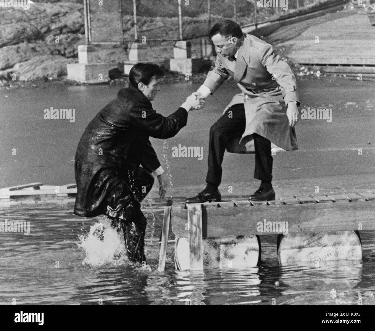 Laurence Harvey and Frank Sinatra doing a scene for the, THE MANCHURIAN CANDIDATE in Central Park, in which Harvey just walked off the pier. 1962. Stock Photo