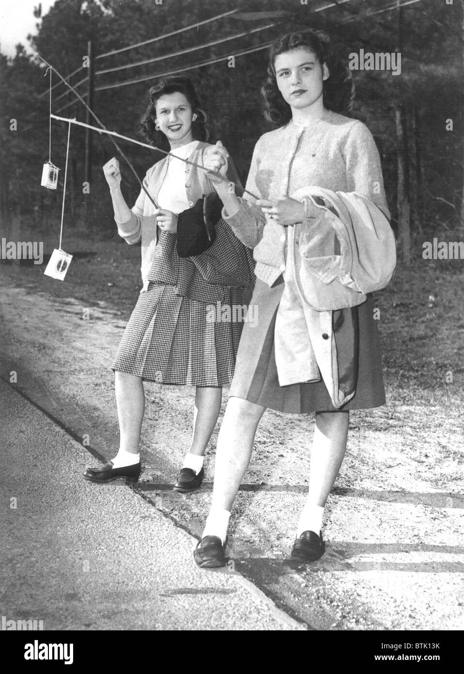 Jane Piazza and Jackie B Canepa hitchhike by waving whole packages of rare cigarettes at passing cars, Newsport News, VA, 3/20/1 Stock Photo