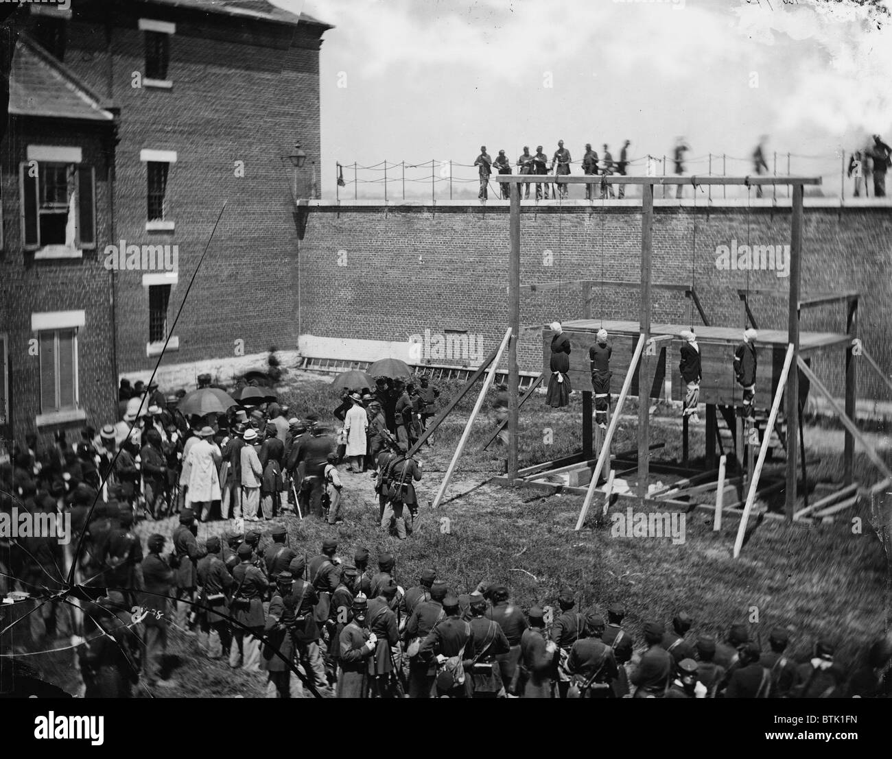 The assassination of President Abraham Lincoln, hanging hooded bodies of the four conspirators, (Mary E. Surratt, Lewis Payne, David E. Herold, George Atzerodt, crowd departing, Washington DC, photograph by Alexander Gardner, July 7, 1865. Stock Photo