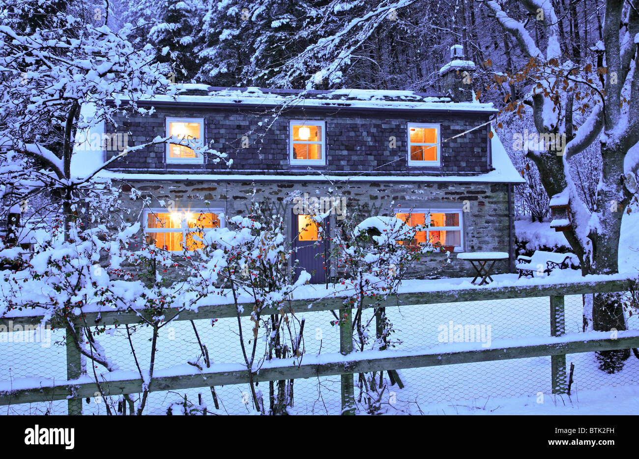 UK Scotland House in snow with lights on Stock Photo