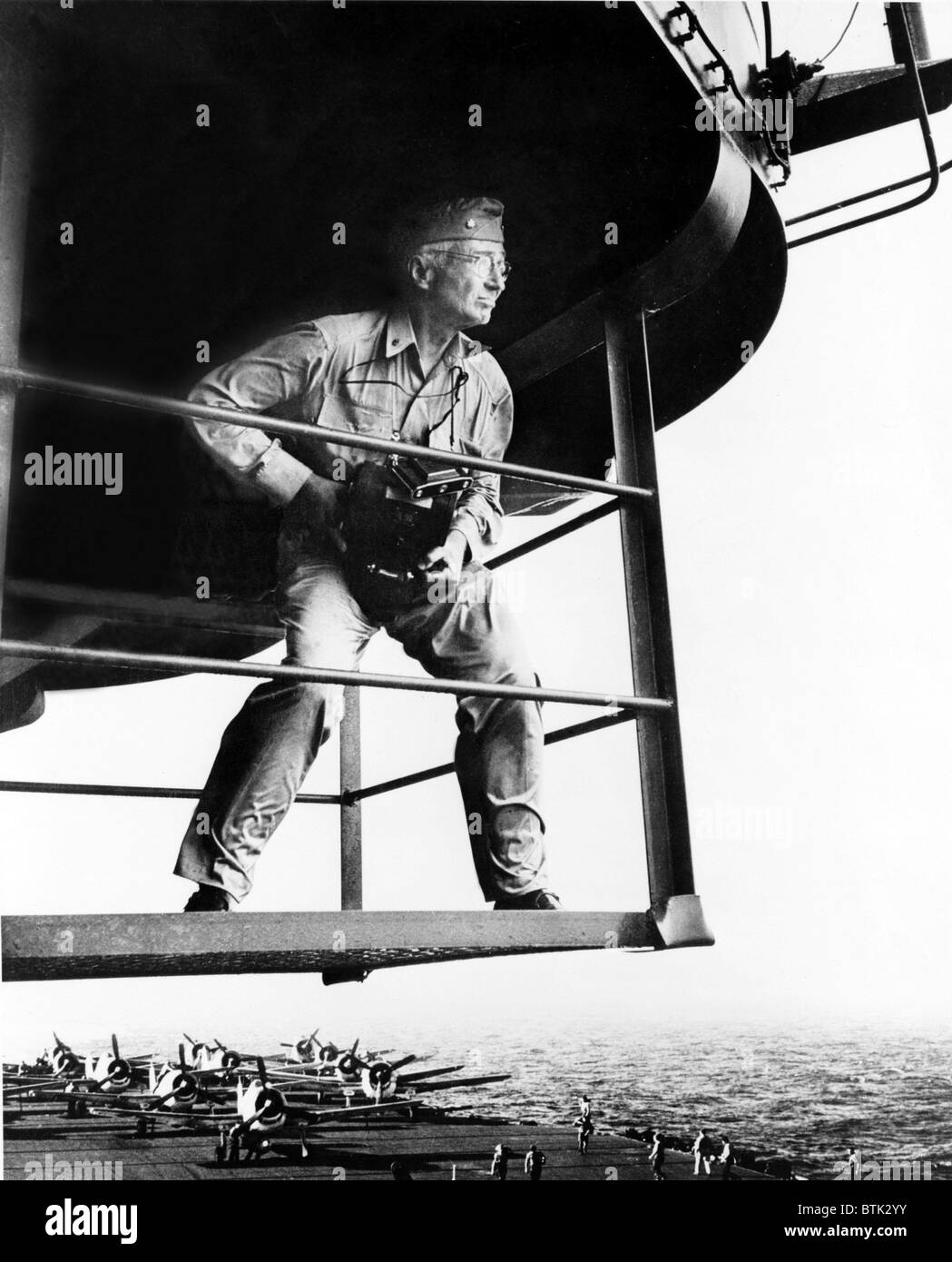 Lt. Commander Edward Steichen (1879-1973) holding camera, standing on aircraft carrier during WWII in 1945. His photographic career started in the pictorialist style; evolved to dramatic fashion photography and portraiture in the 1930. He assumed leadership of US Naval photographic units during World War II. Stock Photo