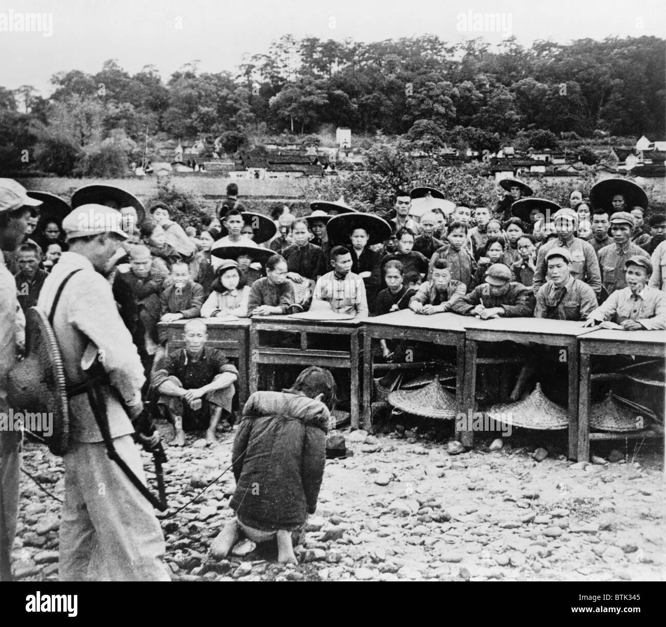 Chinese farmer, kneeling at gunpoint before a court enforcing communist