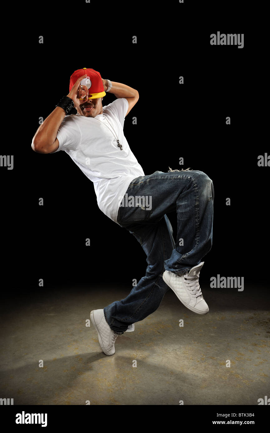 African American hip hop dancer performing over dark background Stock Photo