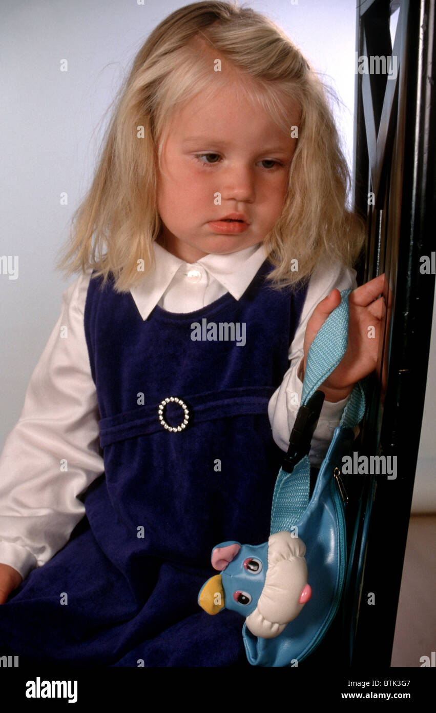 Little girl sitting on chair and looking frustrated. Stock Photo