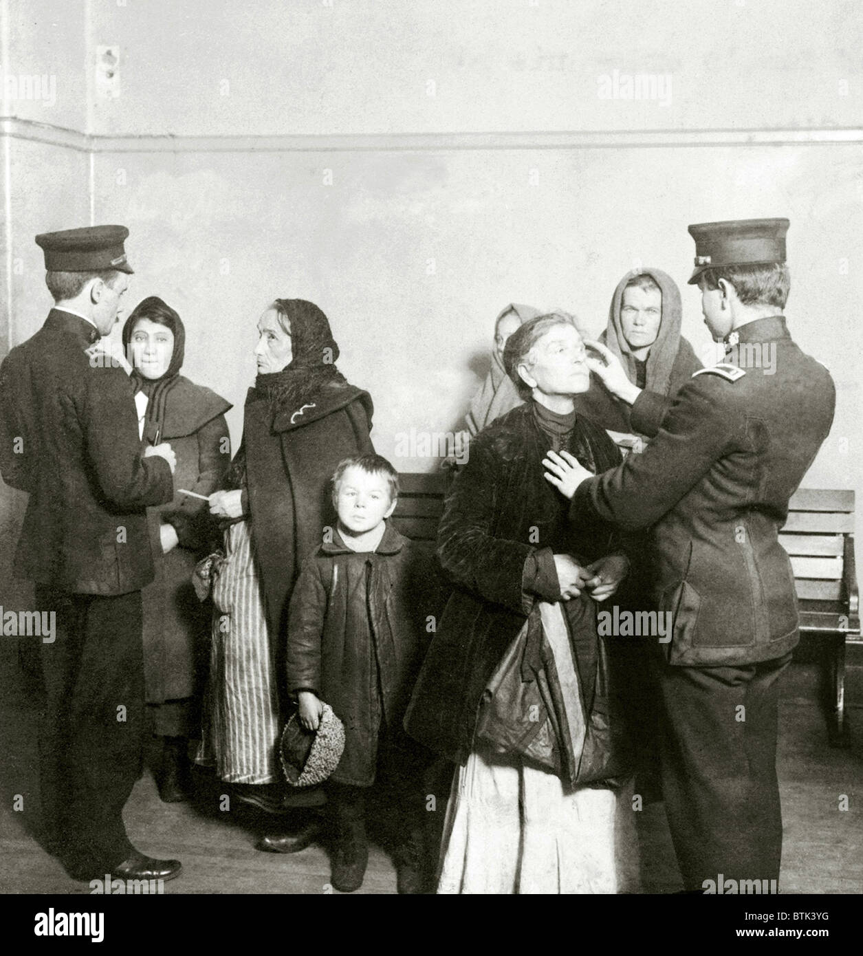 Physical examination of female immigrants at Ellis Island, New York City. The doctor is checking for trachoma, a highly contagious and difficult to cure eye disease. 1911. Stock Photo
