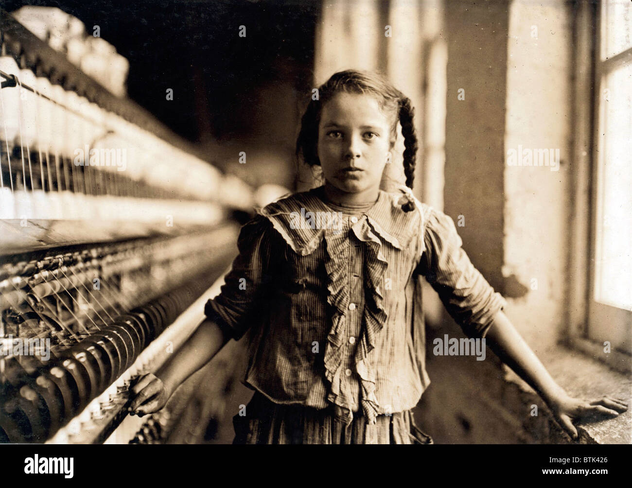 Child laborer portrayed by Lewis Hine in 1908. One of the young spinners in a North Carolina cotton mill earns forty-eight cents a day. Stock Photo