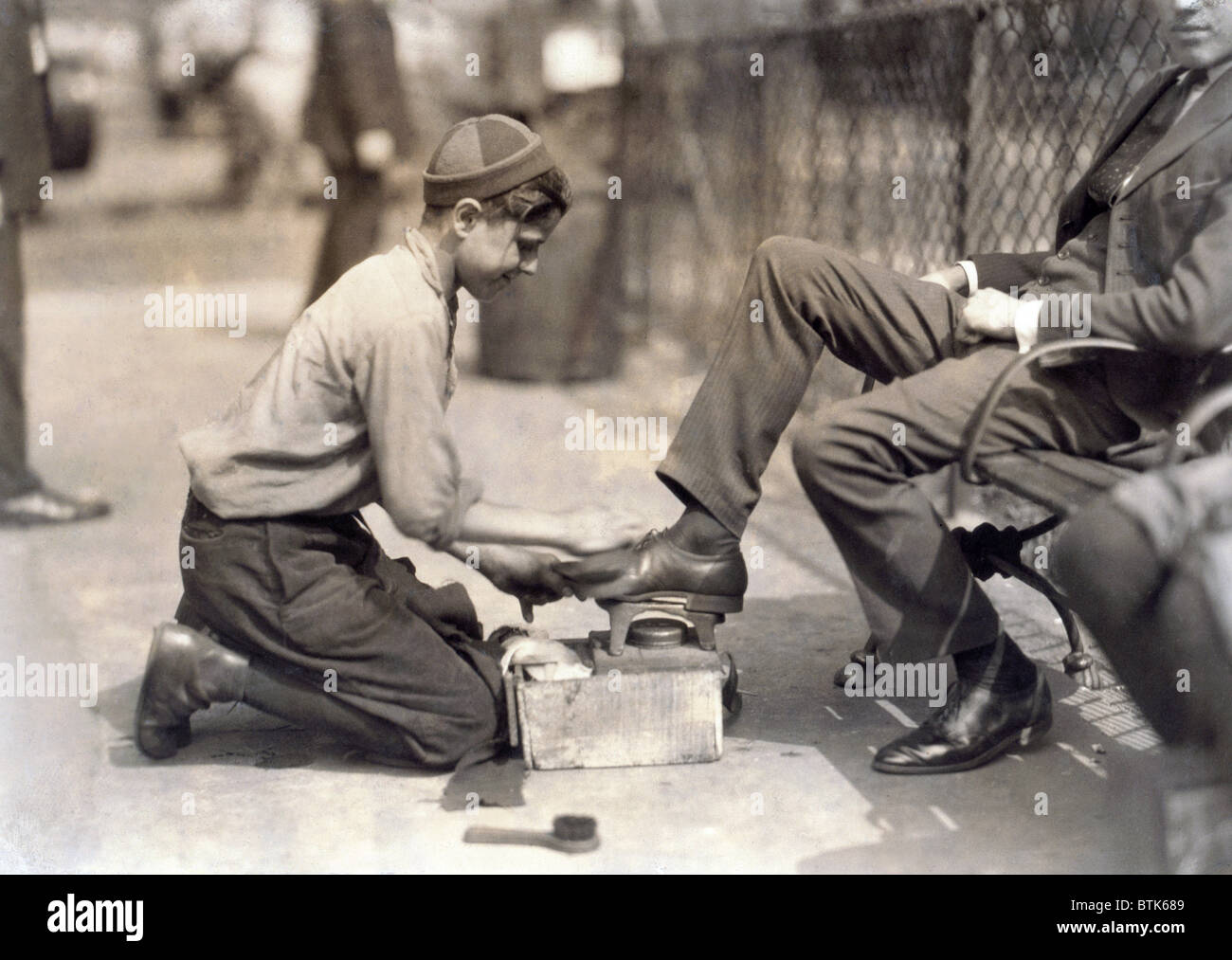 Child labor. Tony, a twelve year old bootblack at his station in Bowling Green, New York City. photograph by Lewis Wickes Hine, Stock Photo