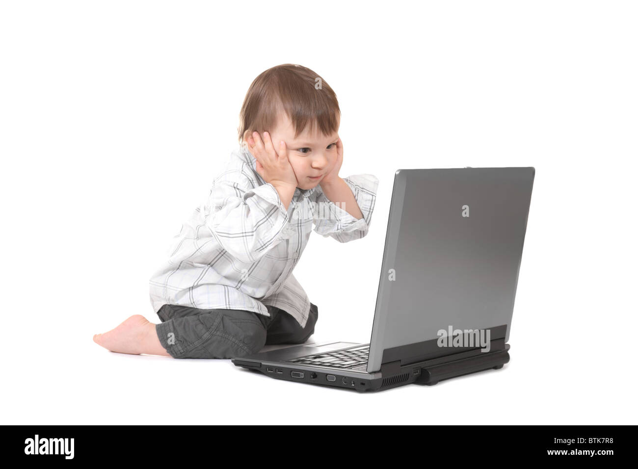 baby holding his head and looking on laptop Stock Photo