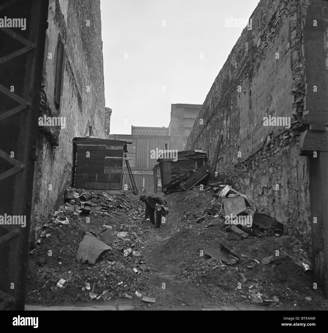 A homeless African American man searches through garbage in a squatter neighborhood along the riverfront in St. Louis, Missouri. 1935 photo by Arthur Rothstein. Stock Photo