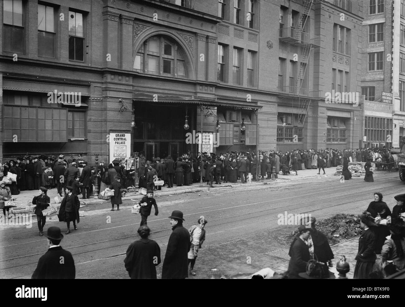 A large crowd of men and women wait outside the Grand Central Palace auditorium for a Salvation Army Christmas dinner in New York during the Depression of 1907-08. Stock Photo